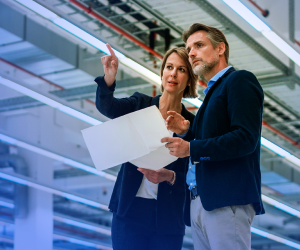 Woman and man looking at paper and discussing facilities